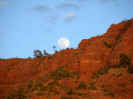 full moon rising over red rocks